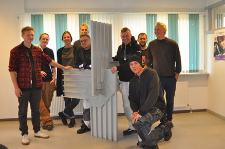 Noen av arkitektstudentene og tømrerlærlingene ved en model av en av samlingene som inngår i bocellen. (Foto: Københavns Tømrerlaug)