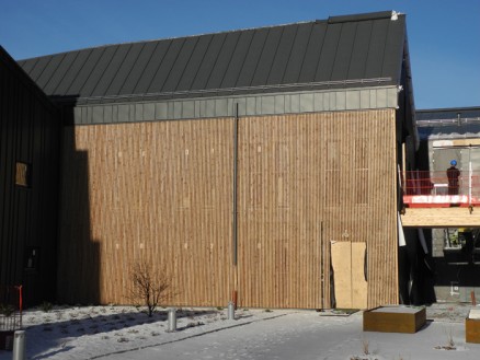 Spilepanel satt sammen av 26x36 mm spiler, måtte monteres med maler for å få riktig avstand. Her trengtes pinlig nøyaktighet. Spilene går i to hele etasjer, også foran vinduer og fungerer som solskjerming. 